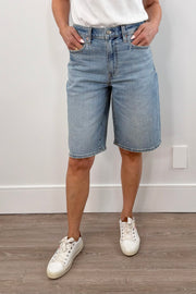 Woman wearing a light blue washed baggy jort