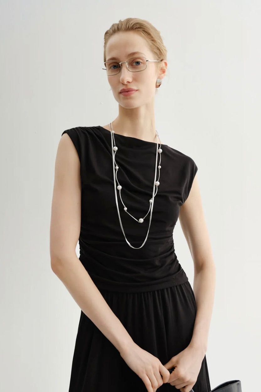 Woman wearing a black wide shoulder tank top