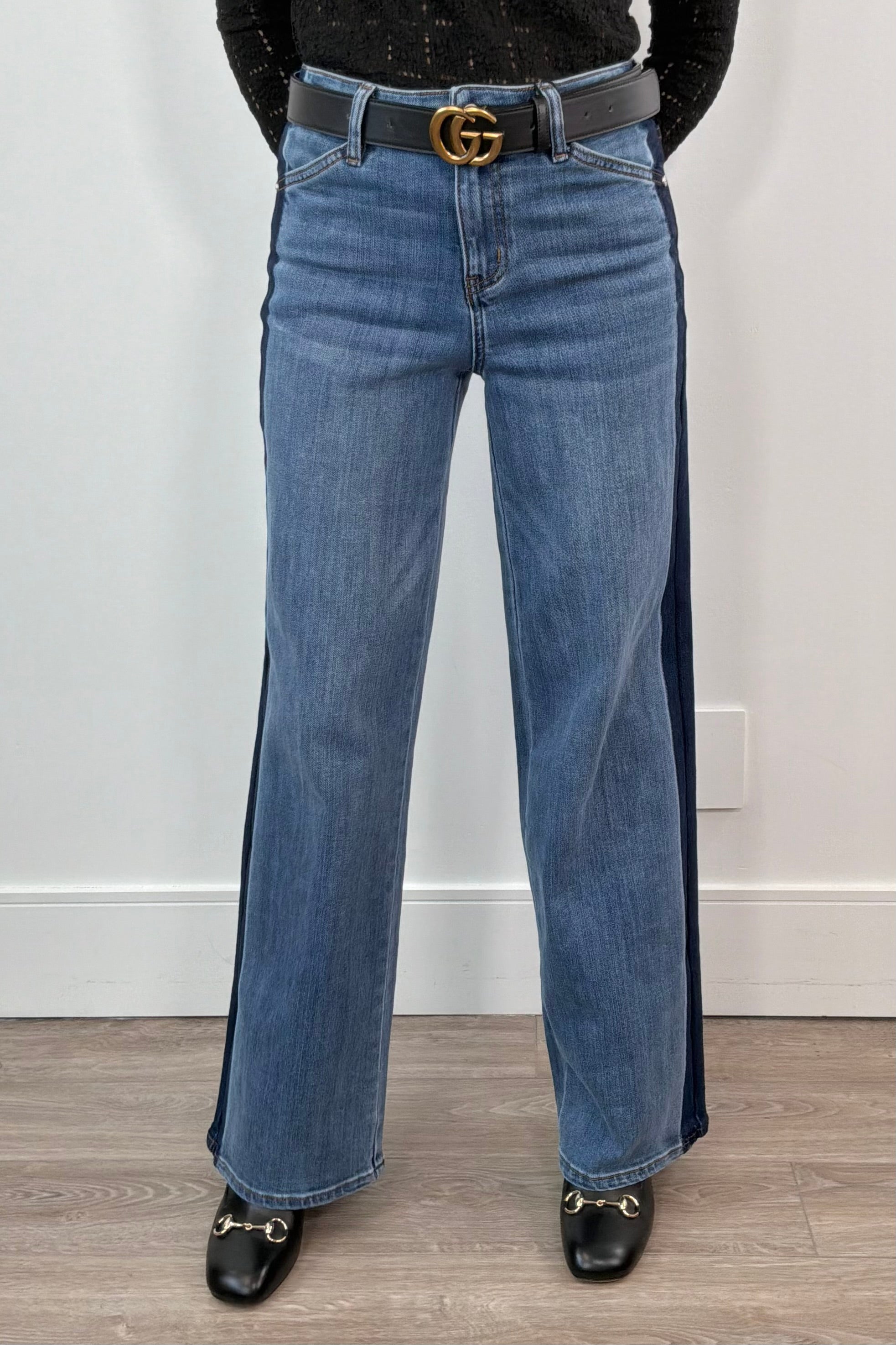 woman wearing blue relaxed straight leg jeans with a navy stripe on the sides