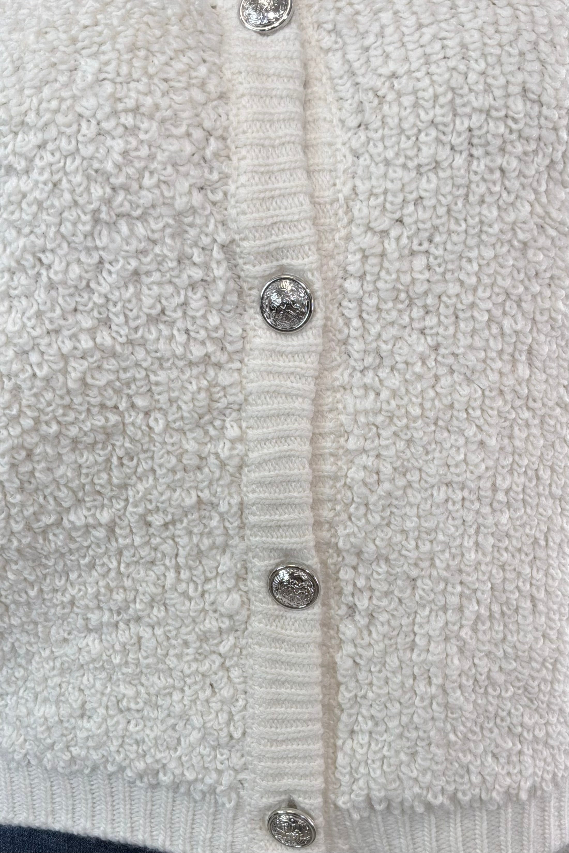 Close-up of a textured cardigan with button details