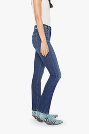 Woman wearing a white tank top and blue mid-rise, straight leg jeans on a white background from the side