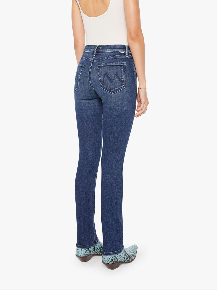 Woman wearing a white tank top and blue mid-rise, straight leg jeans on a white background from the back