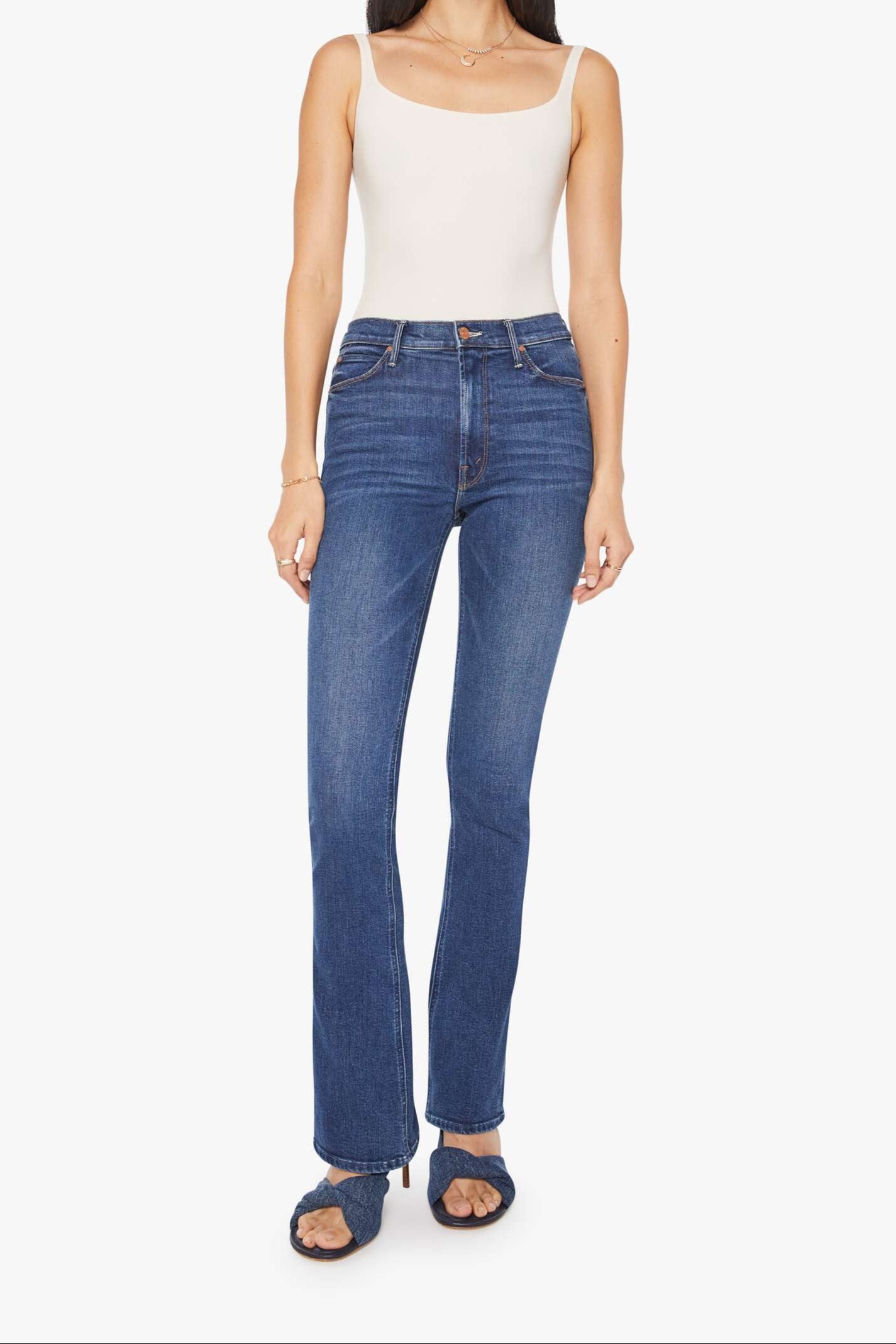 Woman wearing a white tank top and blue jeans