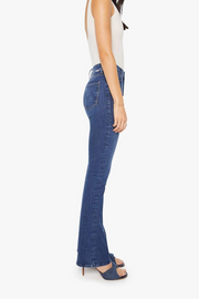 Side view of a woman wearing blue slightly flared jeans 