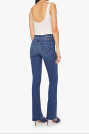 Back view of a woman wearing blue jeans and a white top on a white background