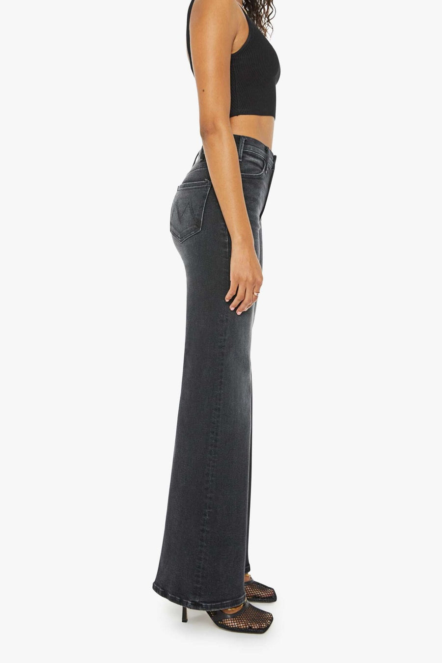 Side view of a person wearing a washed black, wide leg, high rise, and clean hem jean