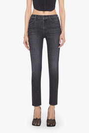 Woman wearing black tank top and dark jeans on a white background