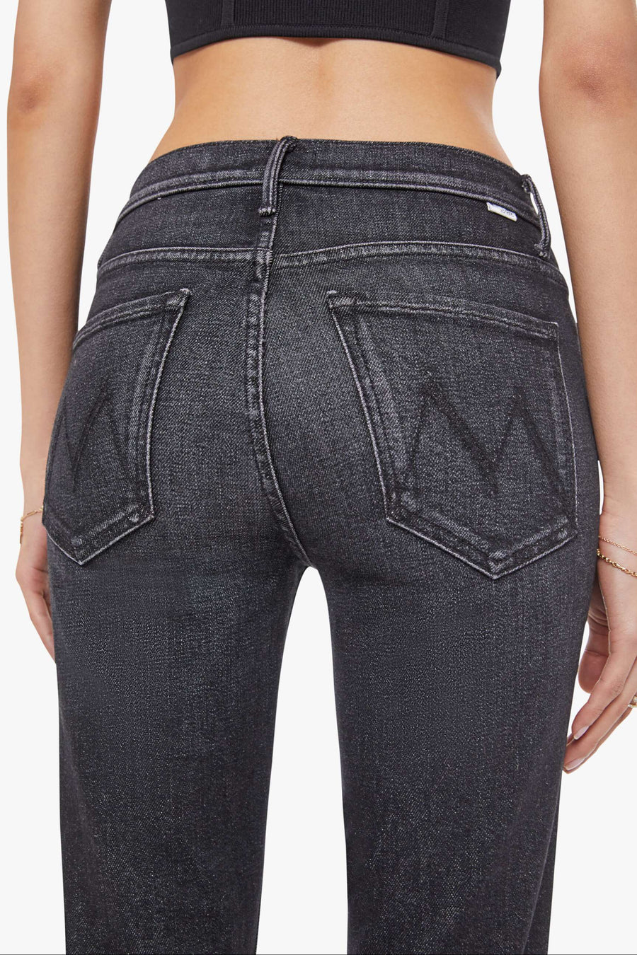 Person wearing dark gray jeans on a white background