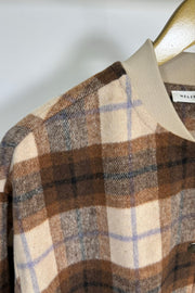 Close-up of the shoulder of a beige/brown plaid bomber jacket