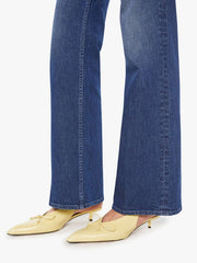 Person wearing blue jeans and yellow shoes on a white background