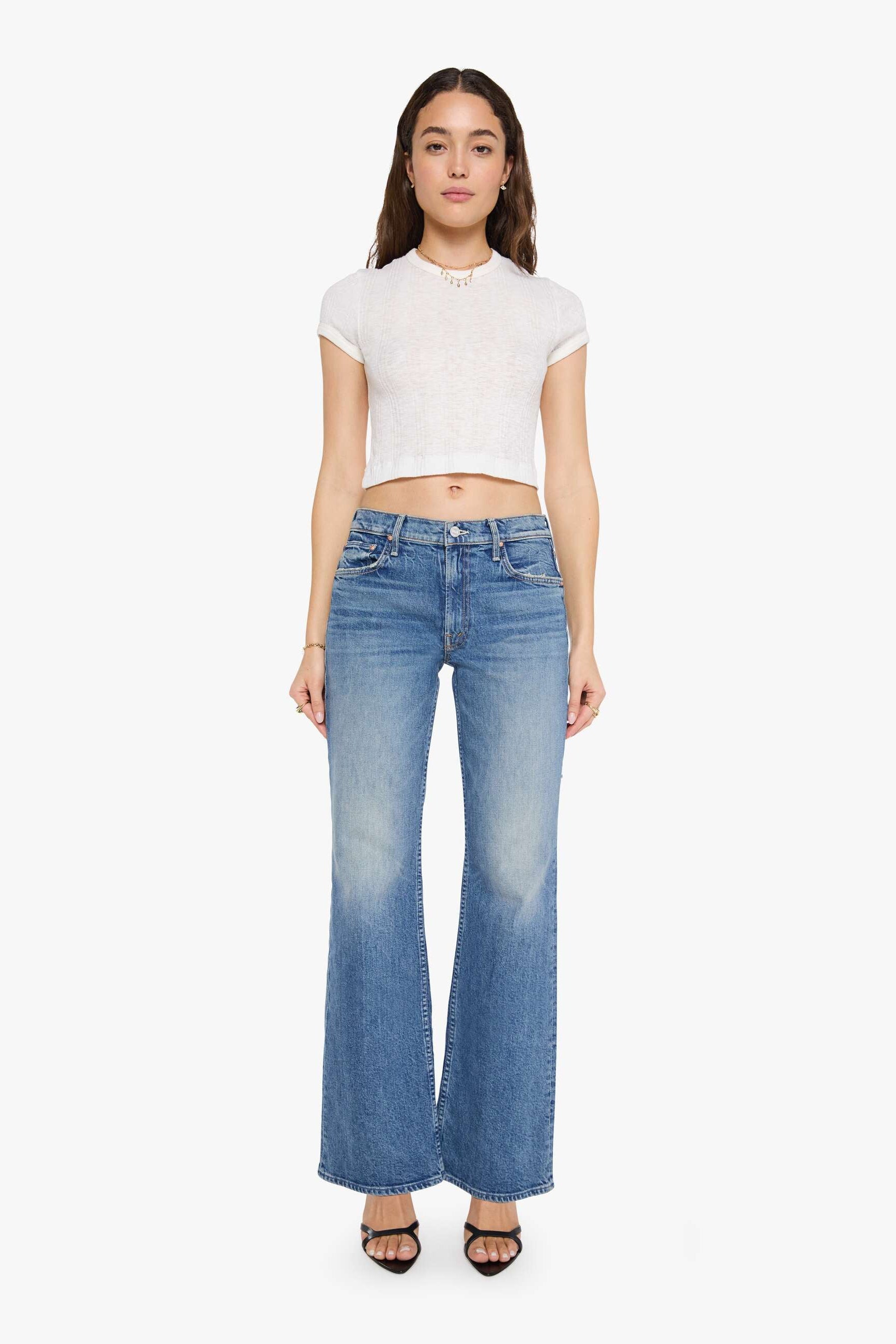 woman wearing mid rise boot cut light wash jeans 