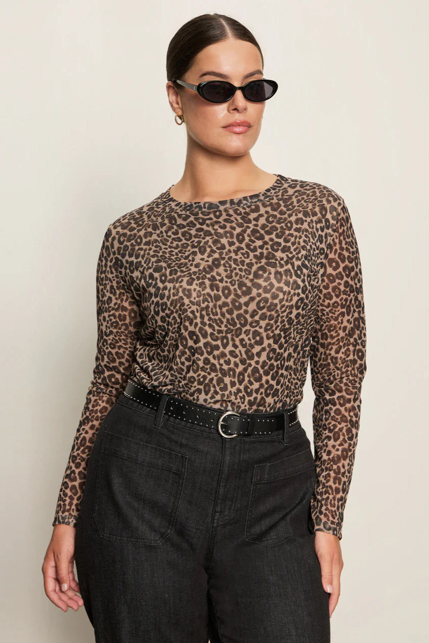 Front view of woman wearing a lined long sleeve leopard print mesh top with black pants