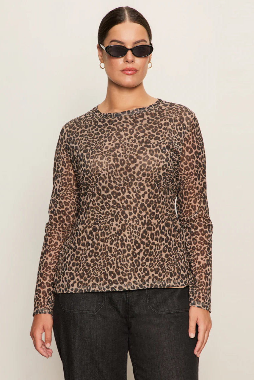 Front view of woman wearing a lined long sleeve leopard print mesh top untucked