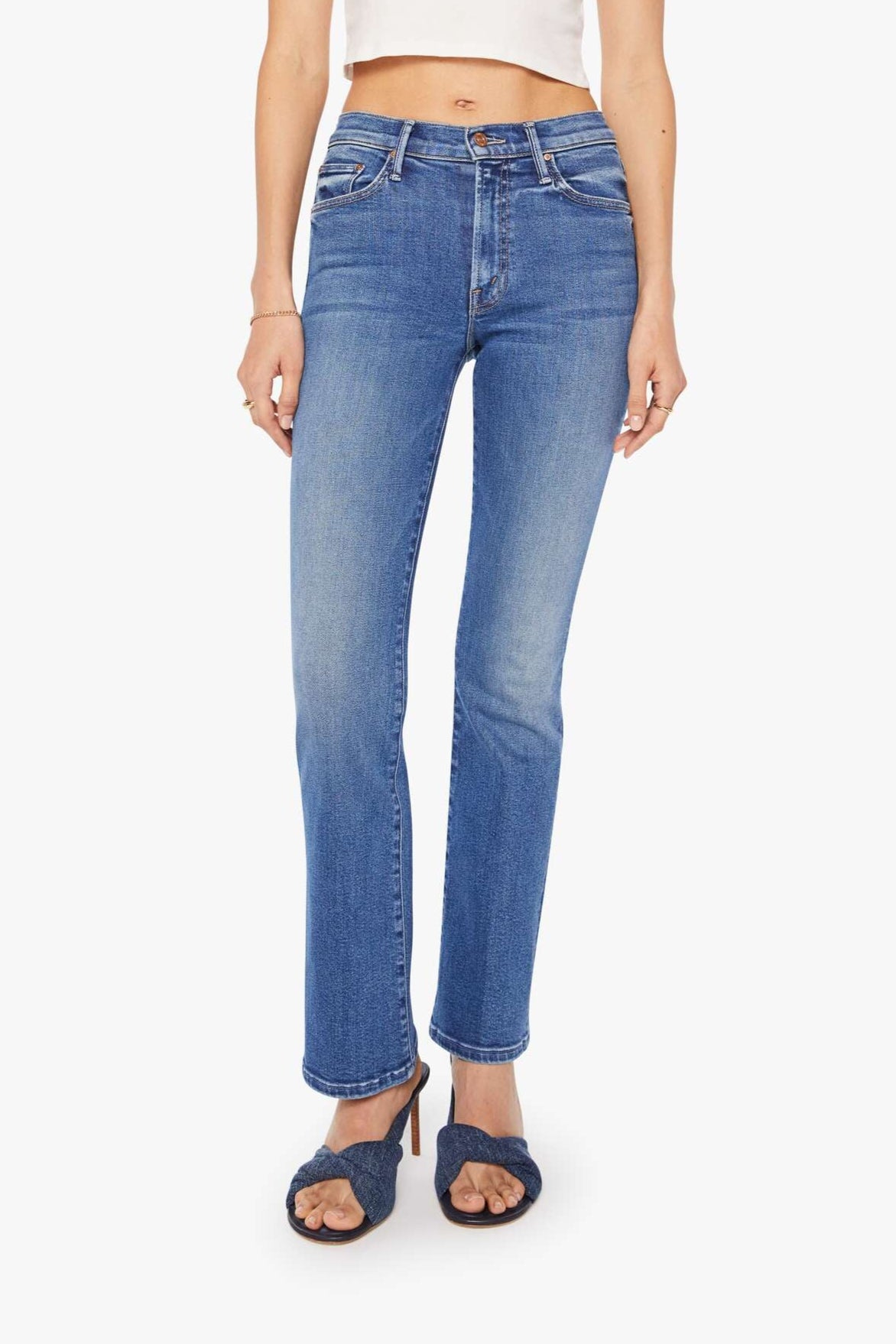 Front view of a person wearing blue mid-rise waist and a narrow flare leg jean