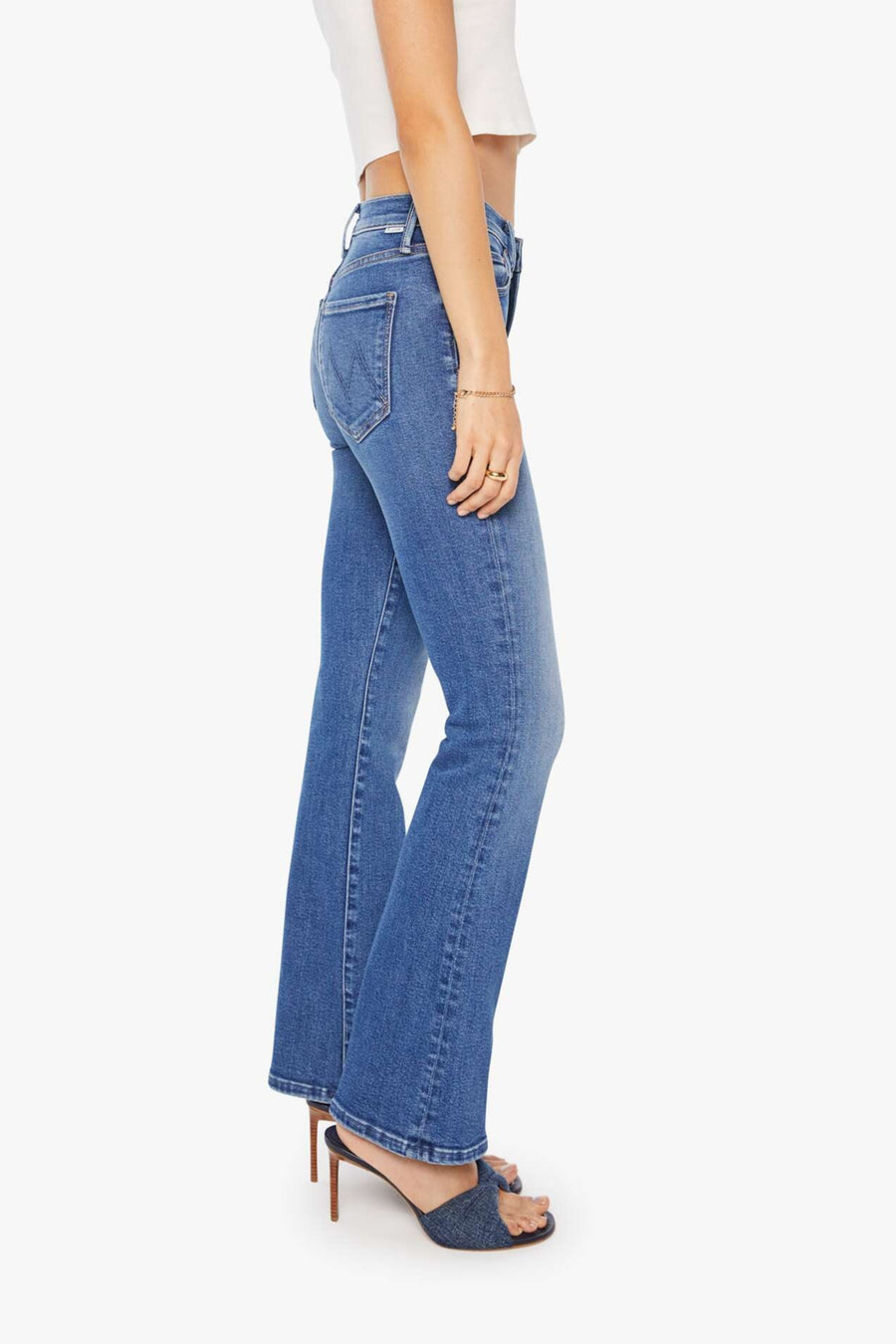 Side view of a person wearing blue mid-rise waist and a narrow flare leg jean