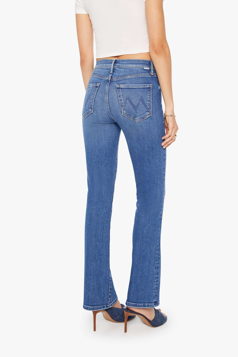 Back view of a person wearing blue mid-rise waist and a narrow flare leg jean