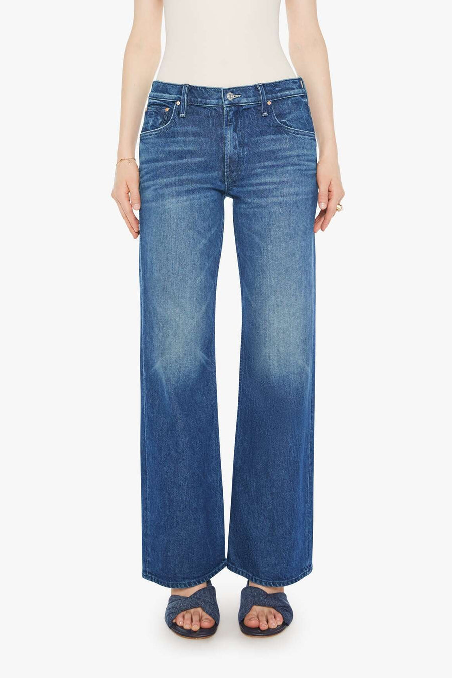 Woman wearing blue jeans and a white top on a white background