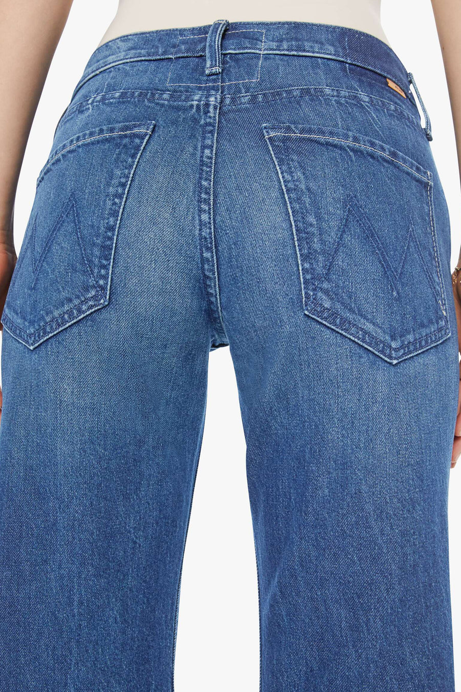 Blue jeans worn by a person on a white background