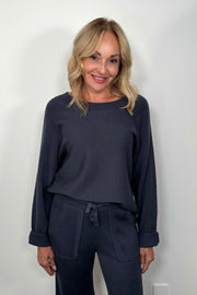 Front view of woman wearing a Cashmere blend blue pullover ribbed sweater tucked in