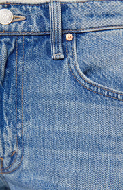 Woman wearing light blue flared jeans with a twist detail