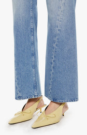 Woman wearing light blue flared jeans with a twist detail