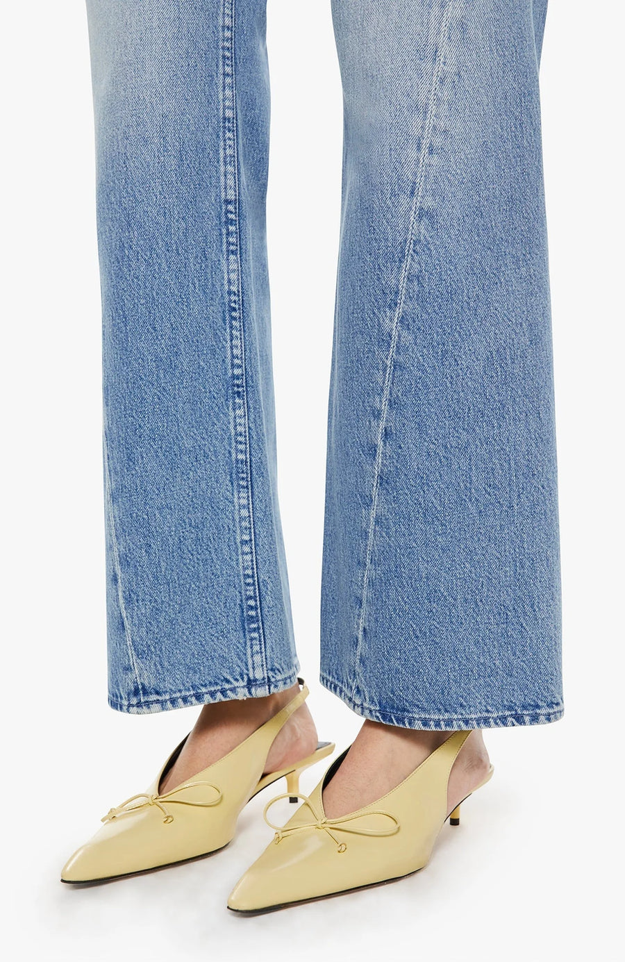 Woman wearing light blue flared jeans with a twist detail
