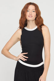 Woman wearing a black sleeveless rib knit tank top with white trim