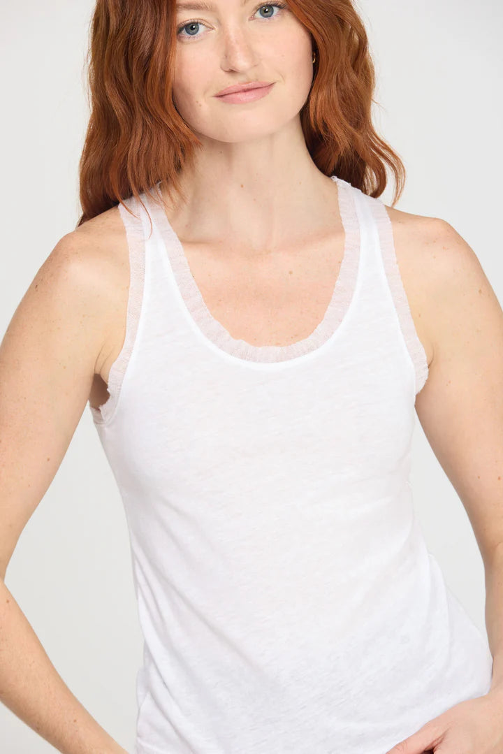 Woman wearing a white tank top with mesh trim 