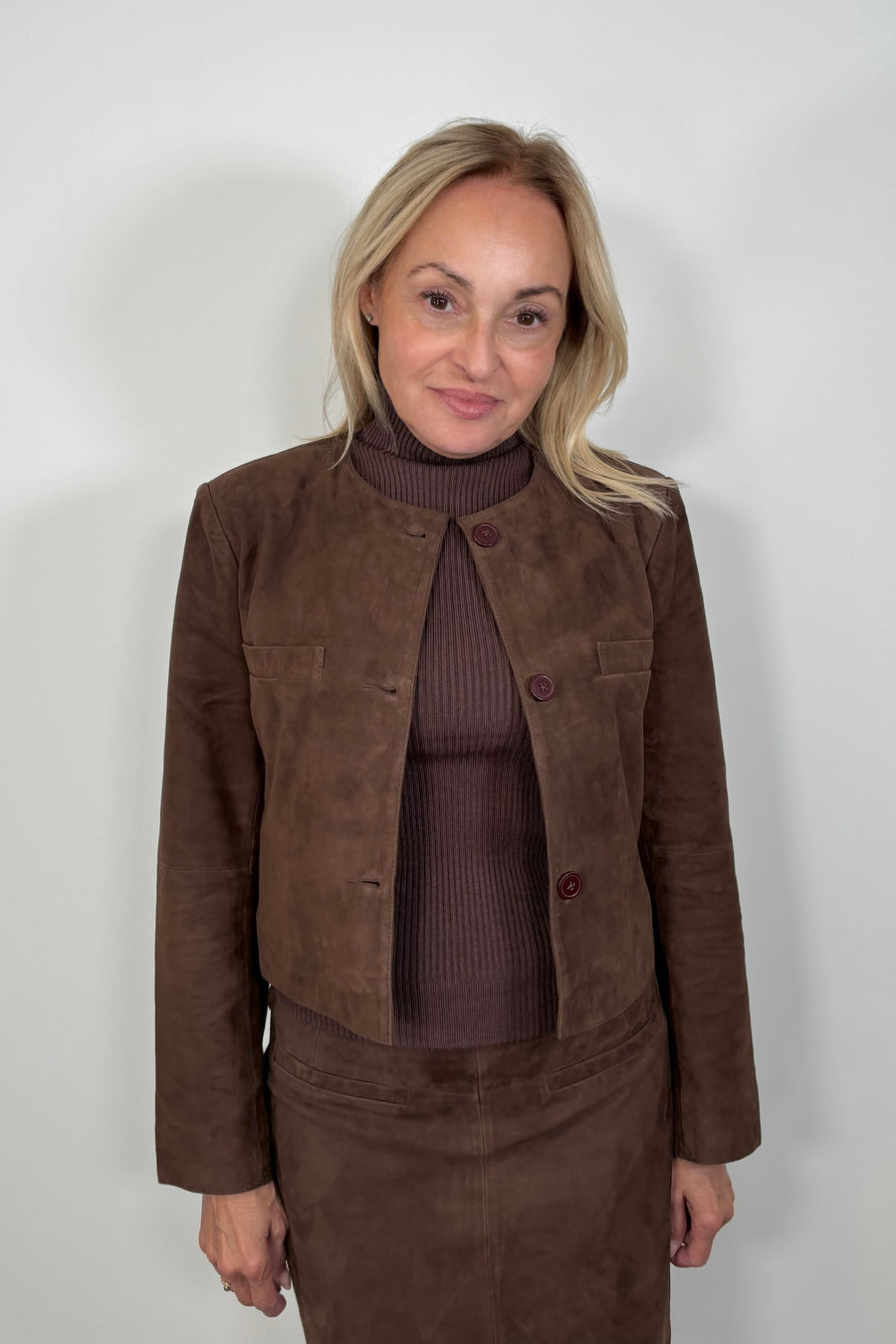 Front view of woman wearing a collarless suede jacket 