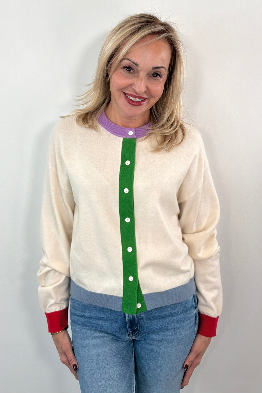 woman wearing a cream cardigan with a green, blue, red and purple accents