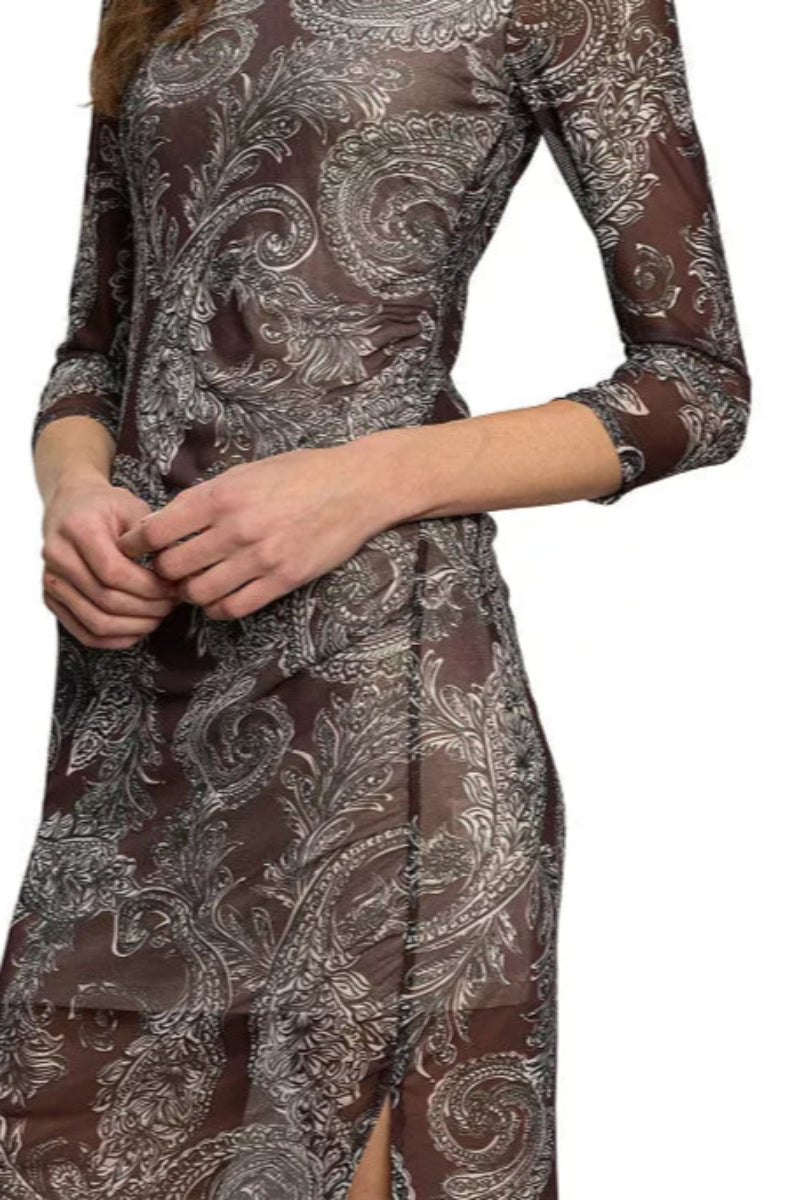 Woman wearing a patterned dress with long sleeves on a white background