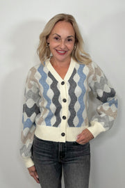 Front view of woman wearing a cardigan with blouson sleeved and a multicoloured waive design