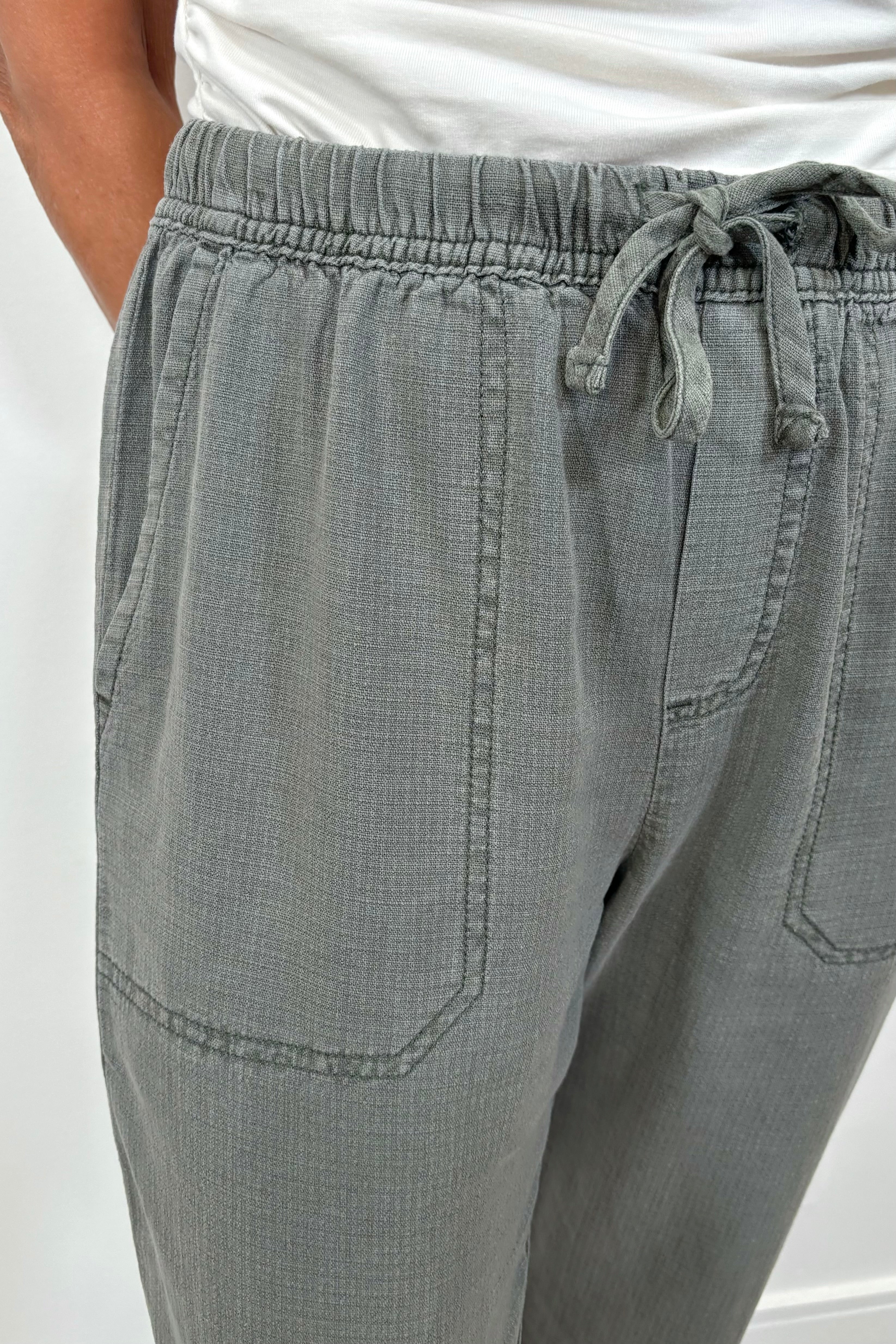 Close up view of a woman wearing green straight leg pants