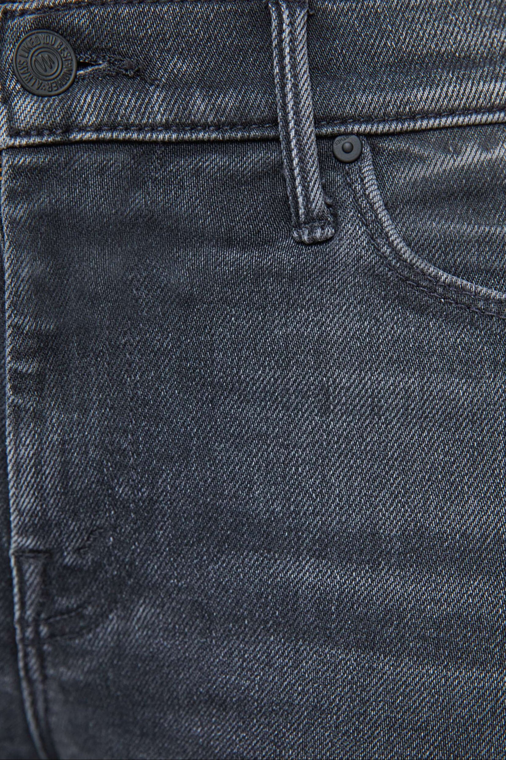 Close-up of washed black jeans with stitching details