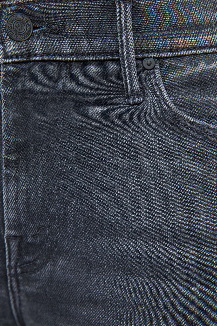 Close-up of washed black jeans with stitching details