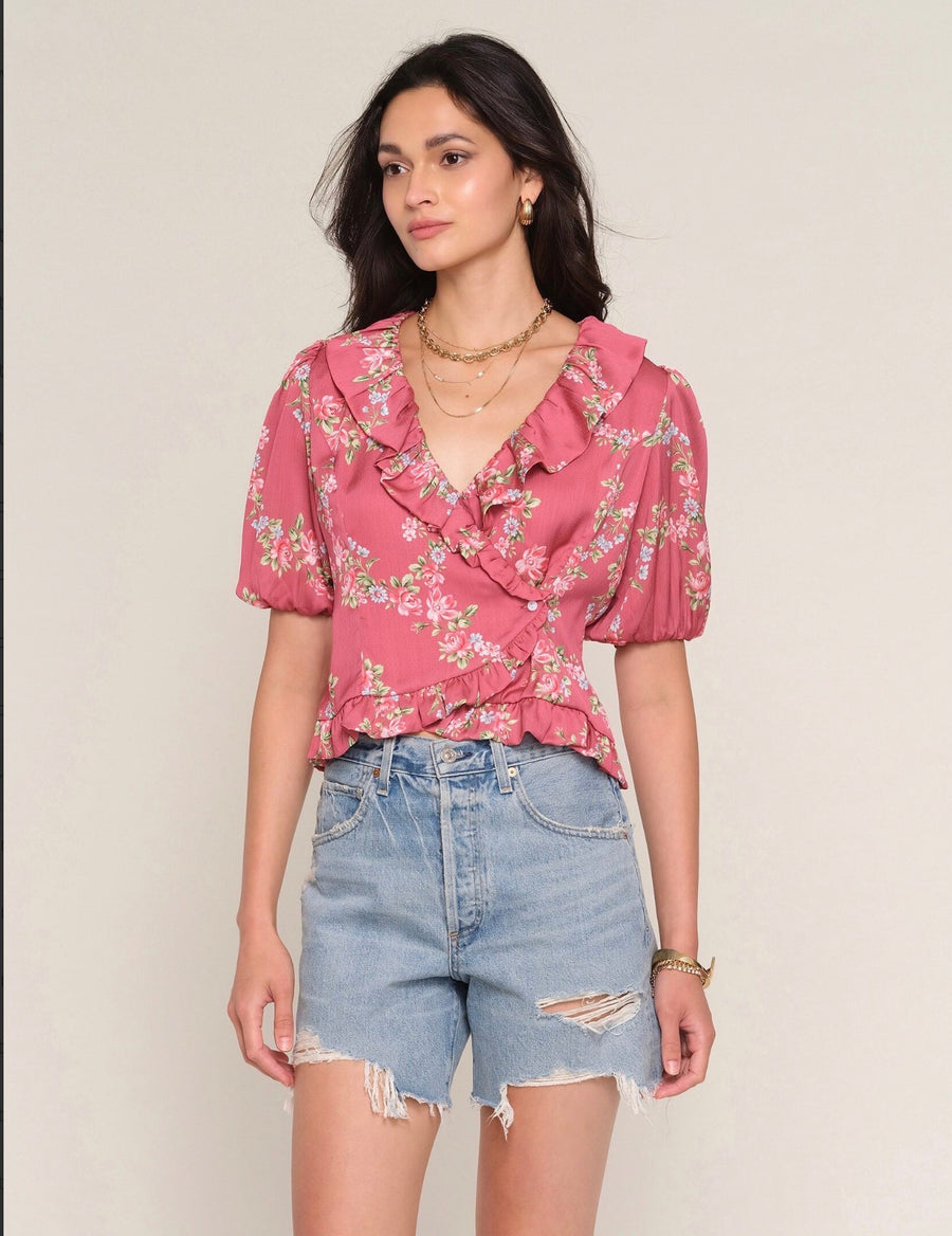 Woman wearing a redl ruffle top with floral print allover