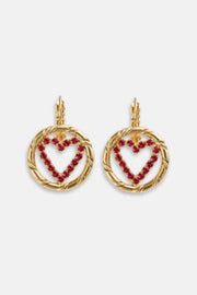 Heart-shaped earrings with red stones on a white background
