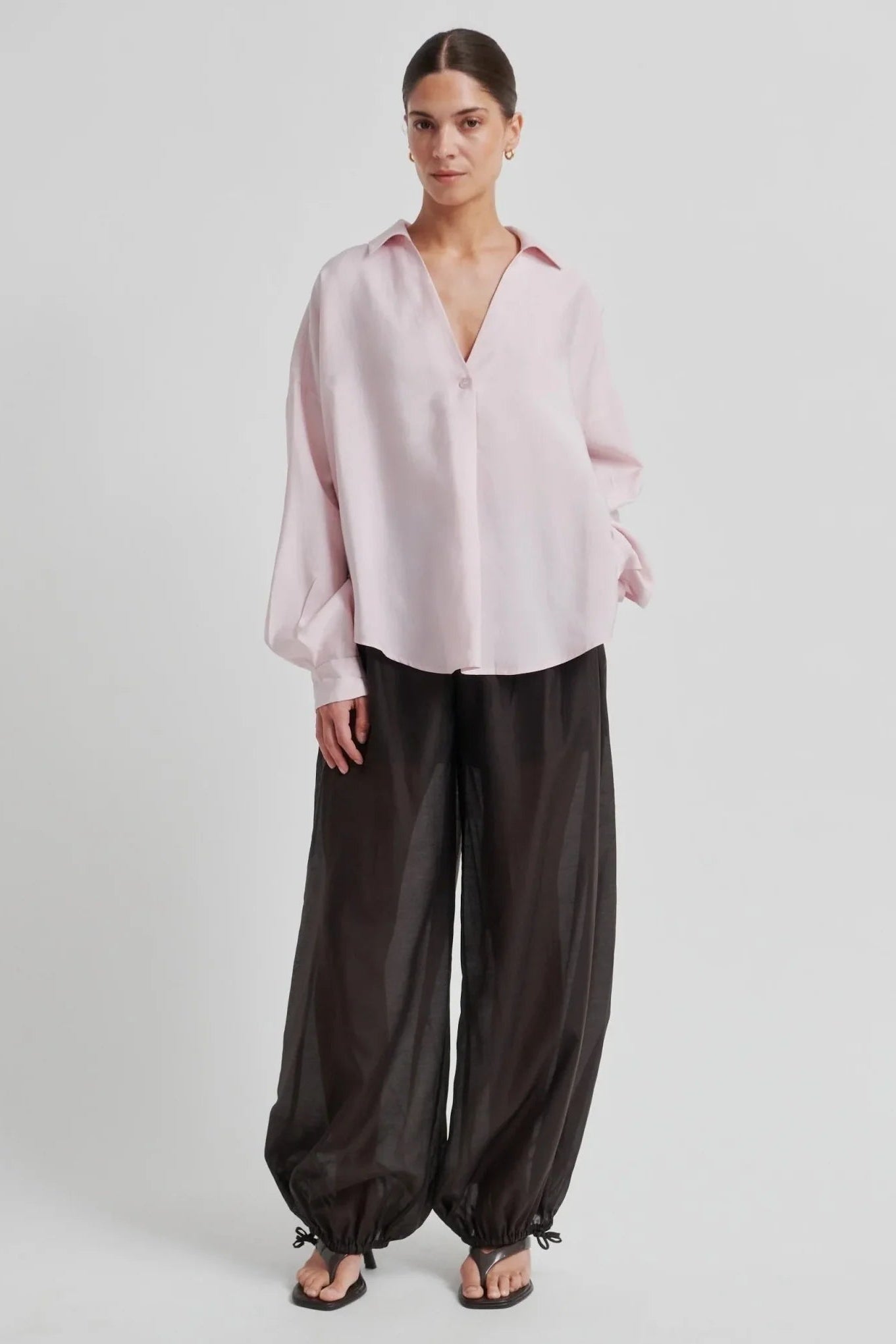 woman wearing a light pink button up blouse 