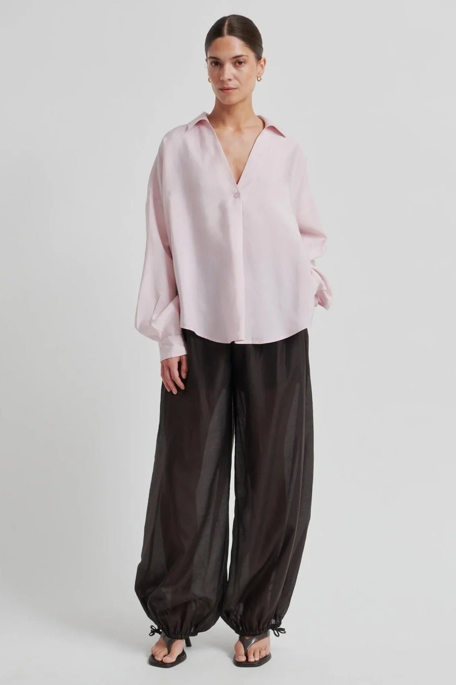 woman wearing a light pink button up blouse 