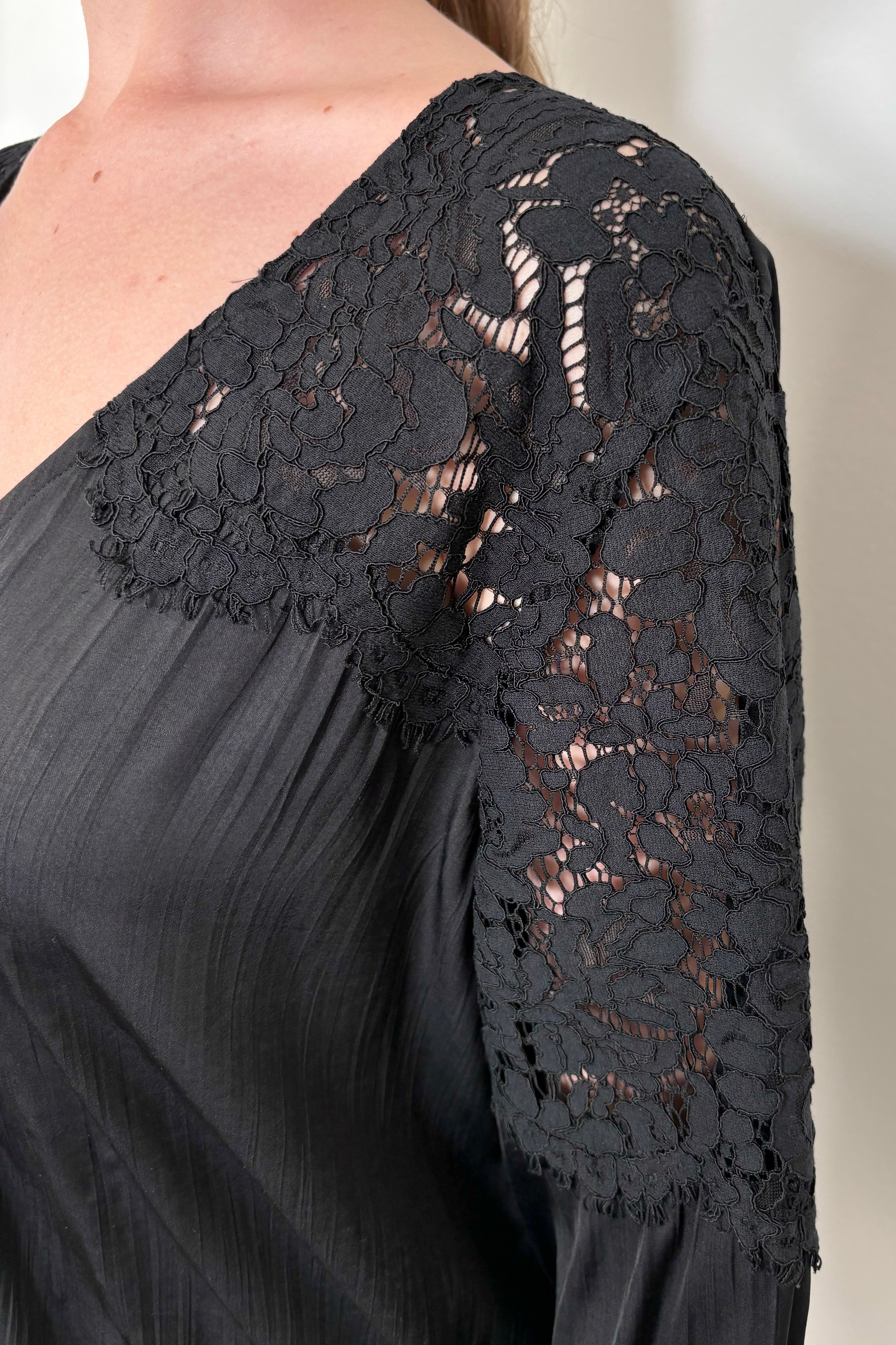 close-up of the lace shoulder of a black satin blouse