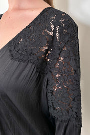 close-up of the lace shoulder of a black satin blouse