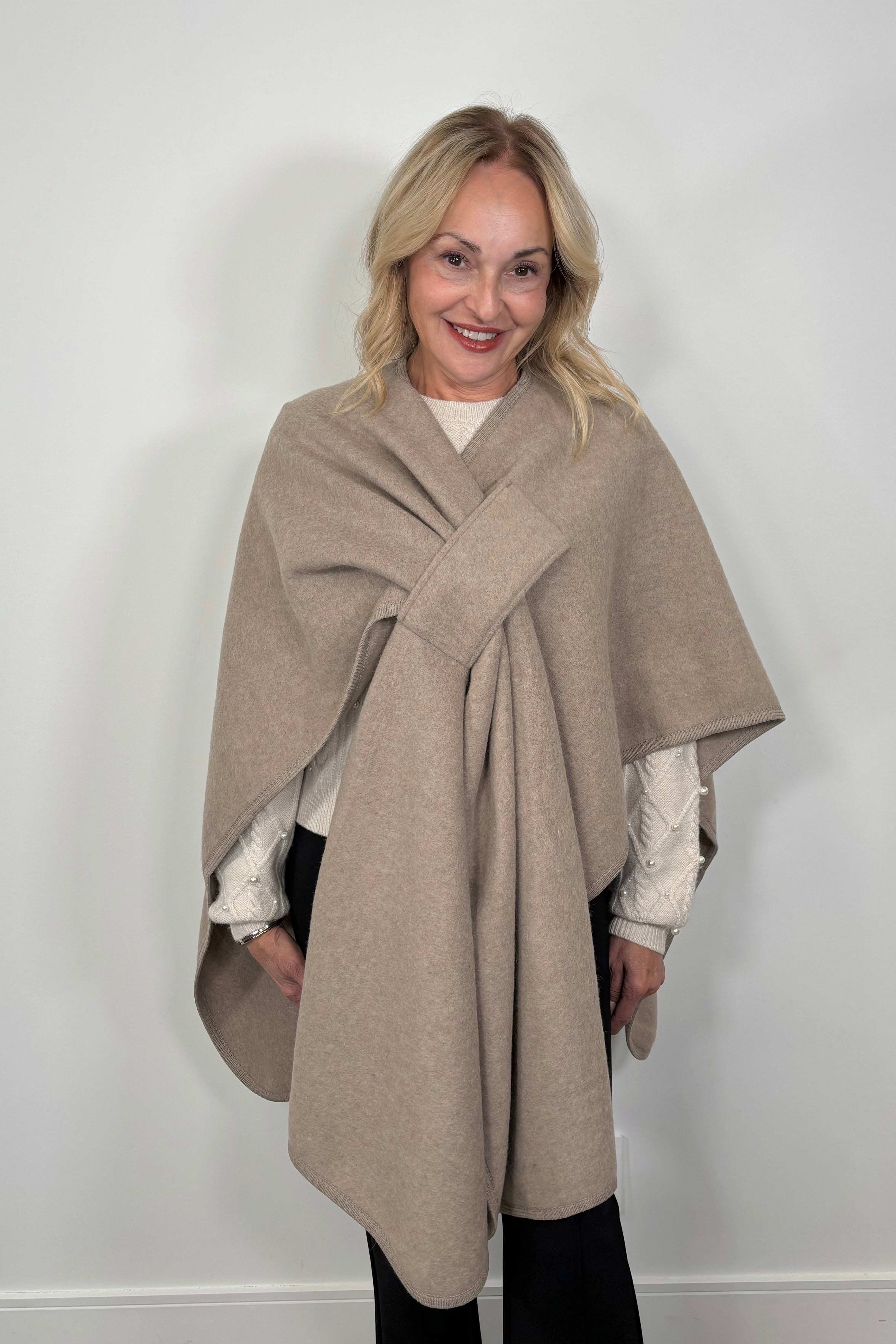 woman wearing a beige cape that looks like a bow