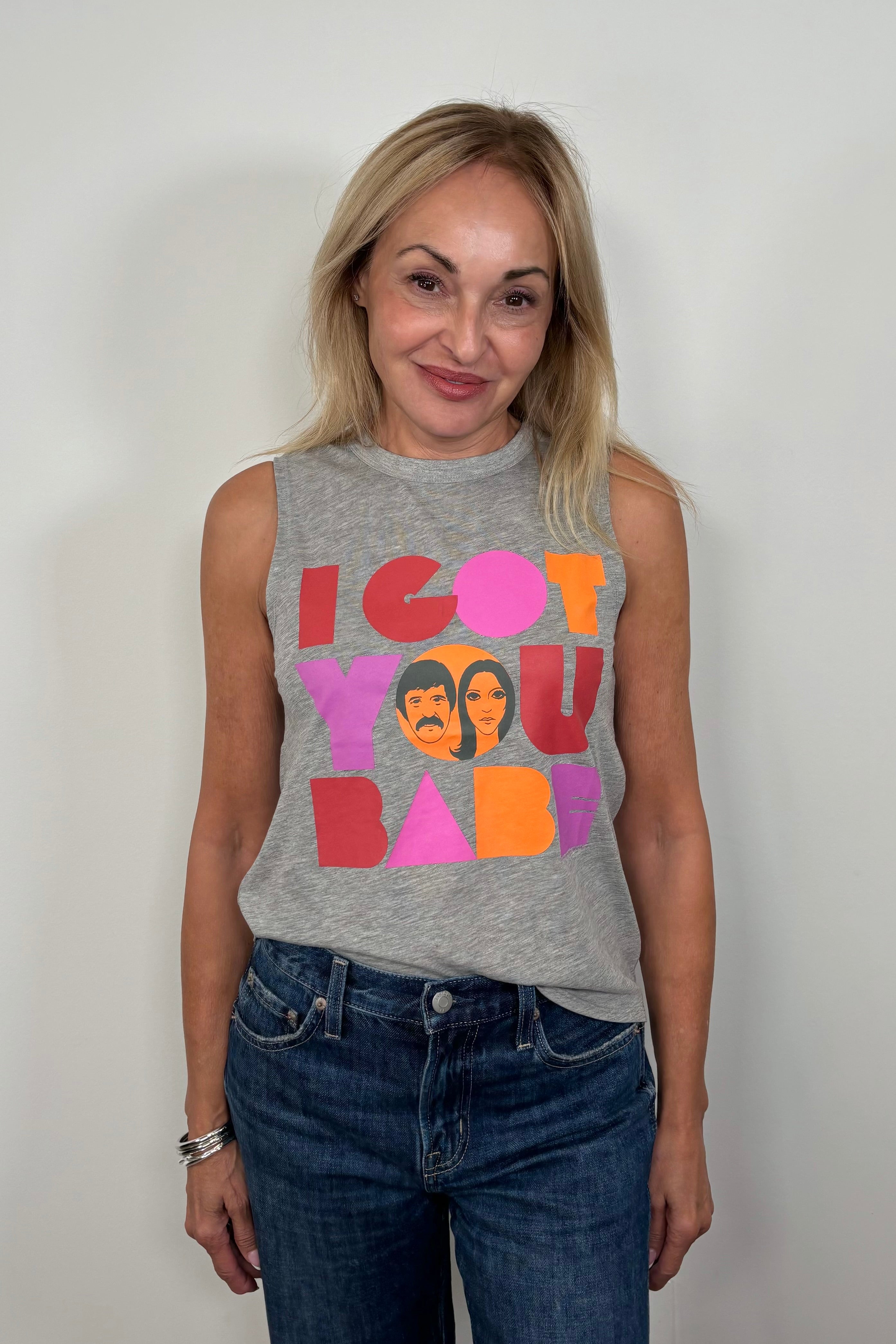 Front facing woman wearing a gray sleeveless tee with “I got you babe” graphic words printed