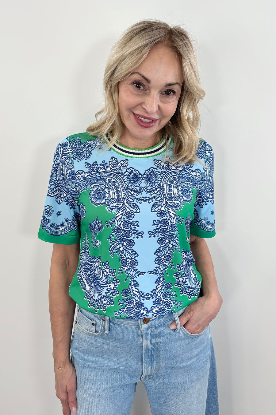 woman wearing a silk green and blue patterned tee