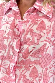 Close up of Woman wearing pink and white long sleeve blouse with jungle print all over
