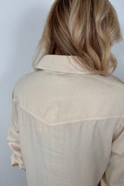 Back view of woman wearing a western snap off-white shirt 