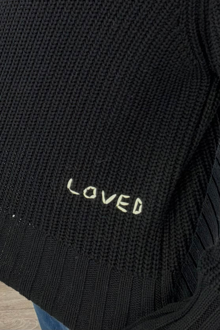 Woman wearing a black sweater with green heart patches