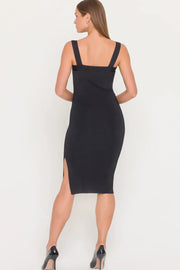 Back view of woman wearing a black dress with gold metal detail on the strap