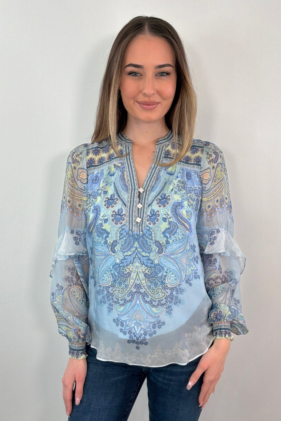 woman wearing a blue paisley patterned silk ruffle blouse
