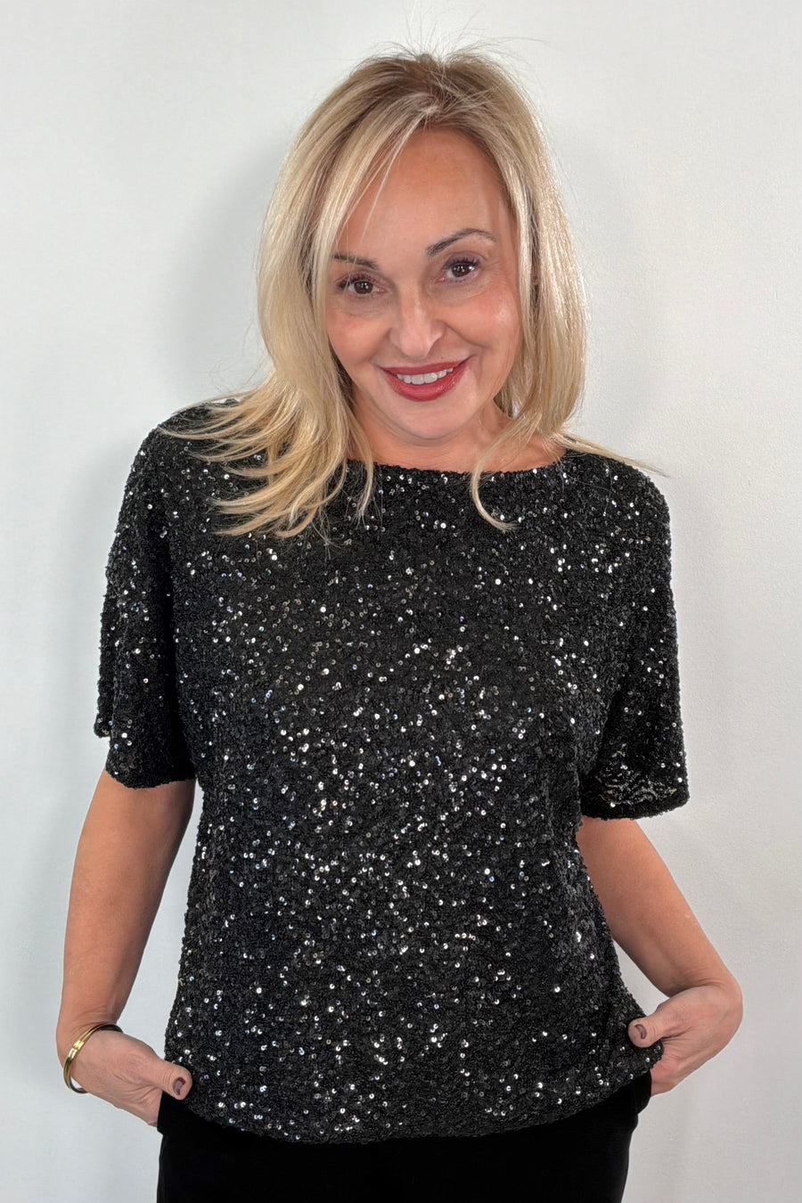 Woman wearing an oversized black sequin top 